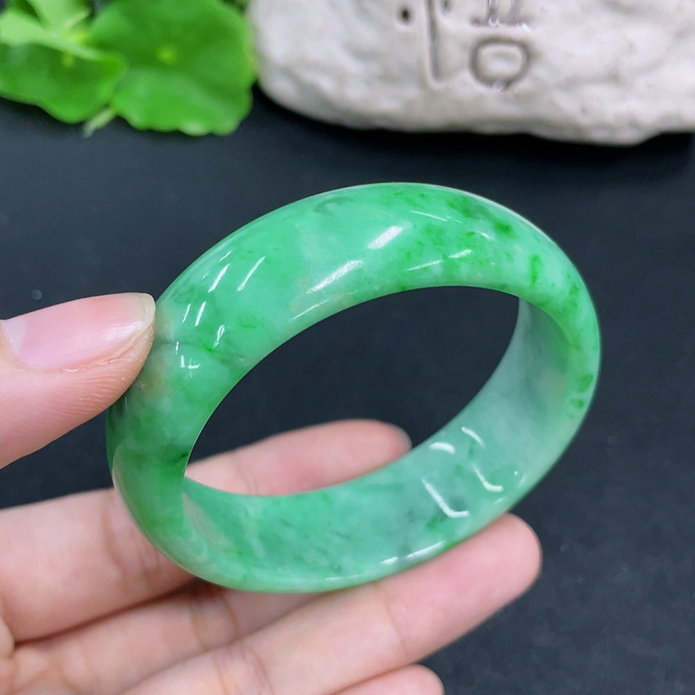 HKHQ jadeite concubine bracelet with 54.1/48.8 size, crafted in green jadeite, weighing approximately 49.57g.