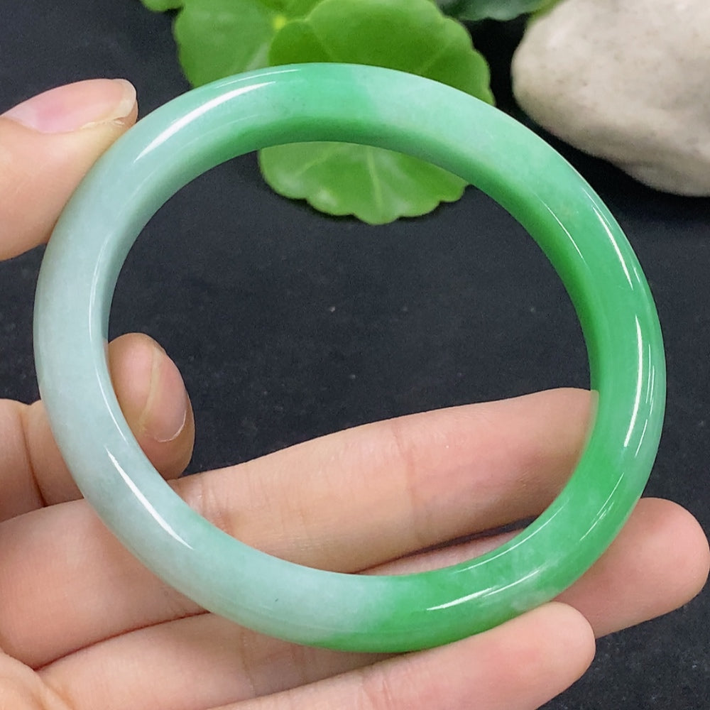 HKHQ Jadeite oval bangle in size 53.5, weighing 38.88g, with smooth, polished surface and elegant oval shape.