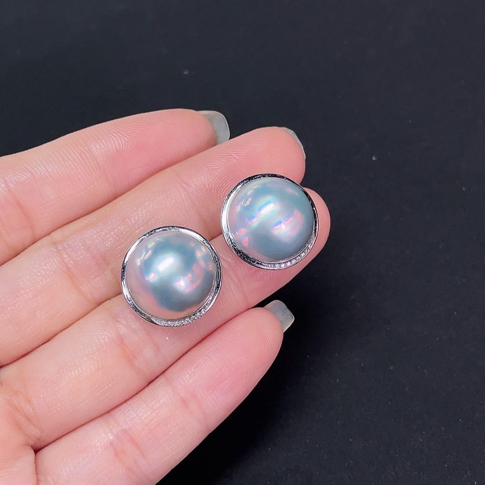 HKHQ composite saltwater pearl stud earrings with platinum settings and diamond accents, close-up view of elegant jewelry.