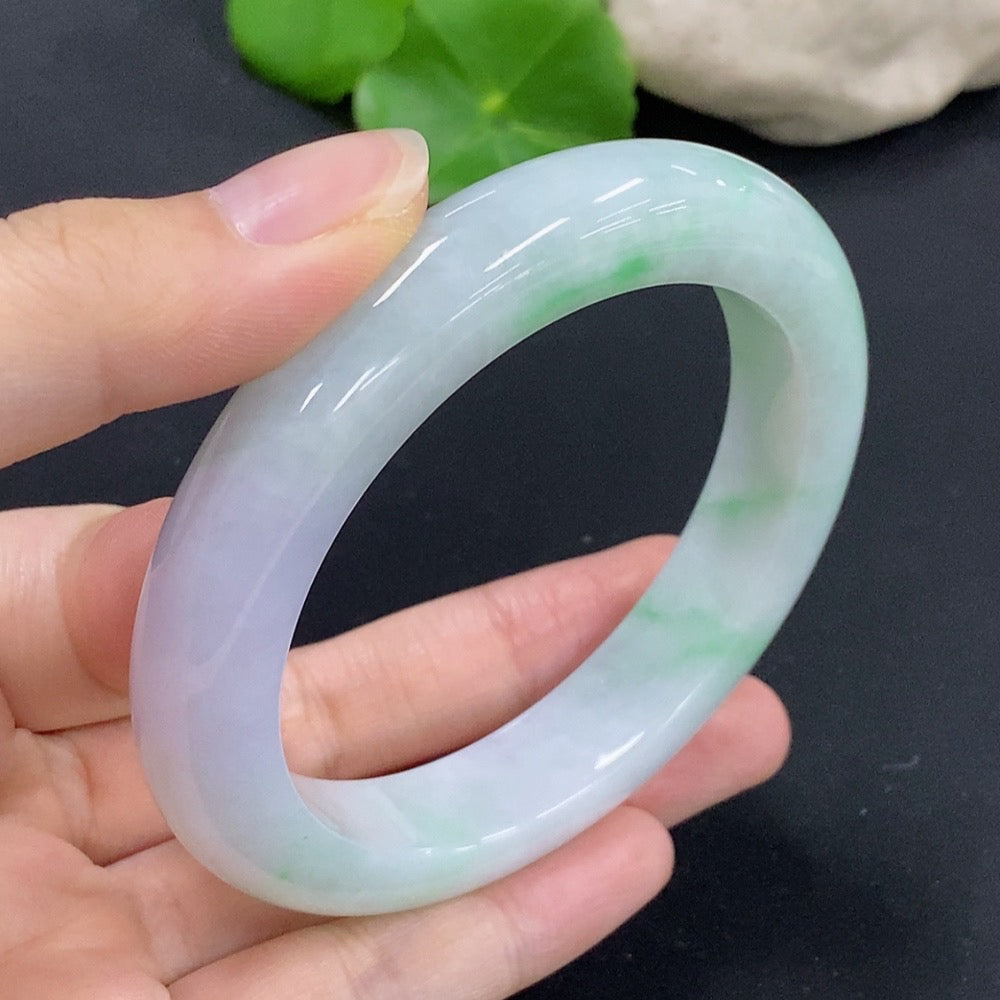 HKHQ jadeite round bangle in size 58.9 with a polished finish, showcasing its smooth, vibrant green jadeite surface.