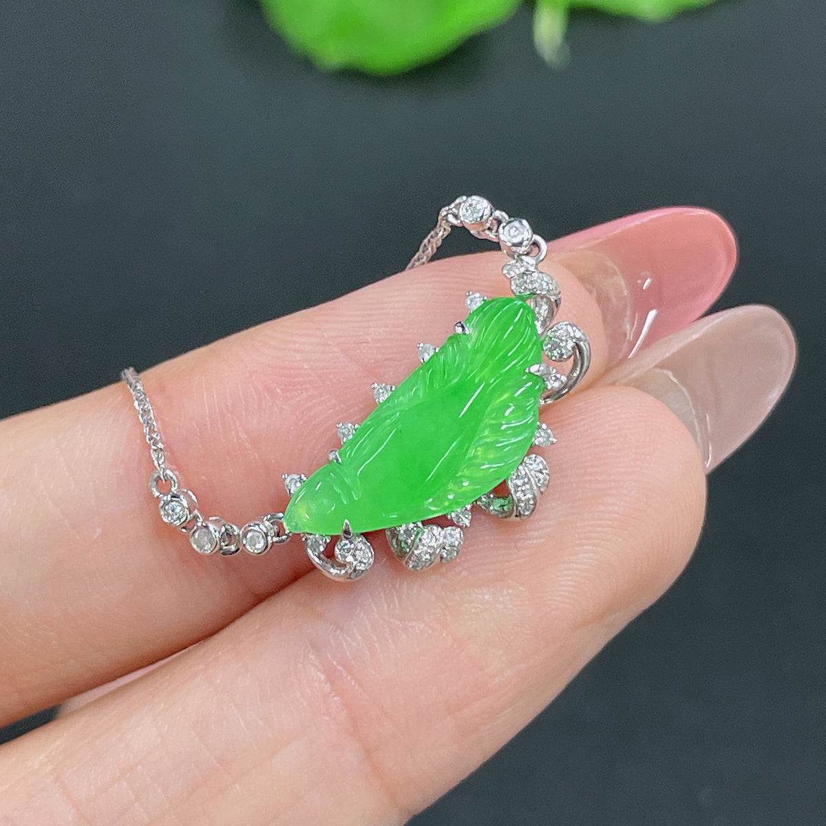Jadeite pendant with 18k gold inlay and diamond accents, hanging on a matching gold chain, weight approx. 2.61g.