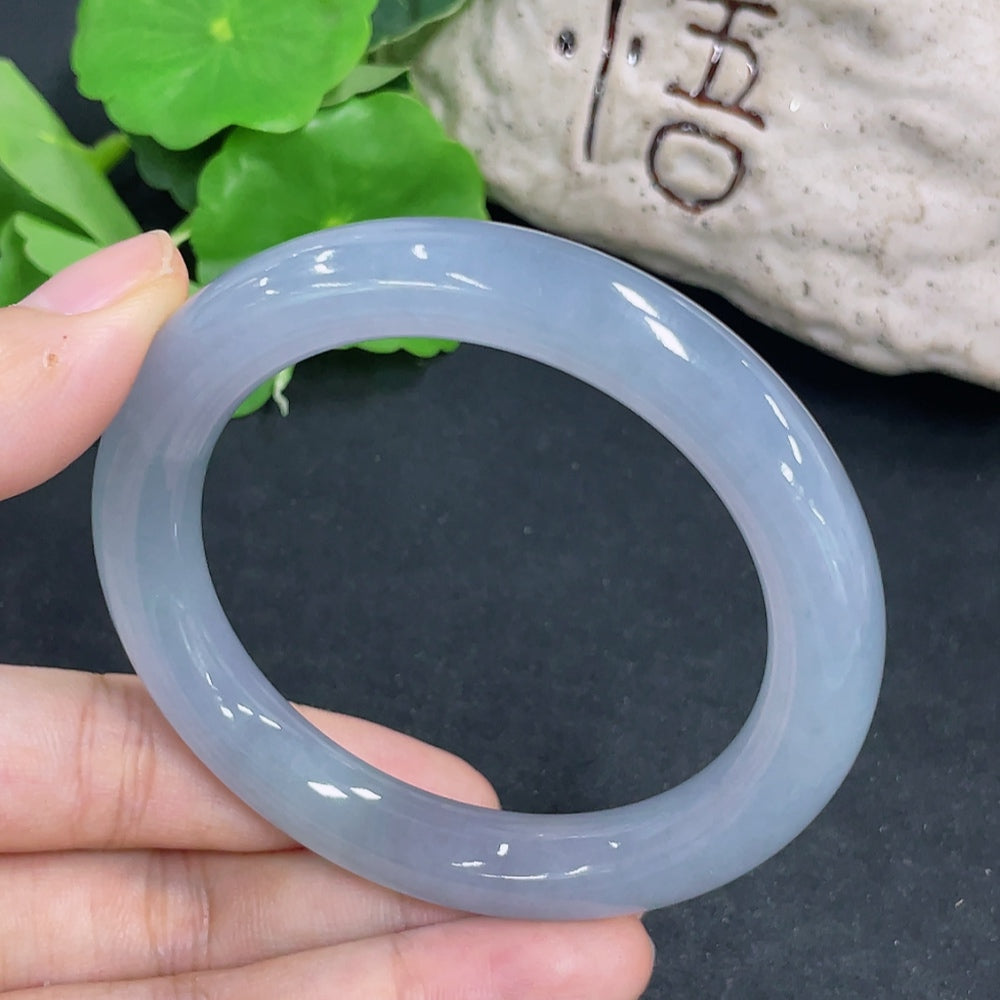Handcrafted jadeite round bangle from HKHQ, showcasing smooth, polished green jade with a glossy finish.