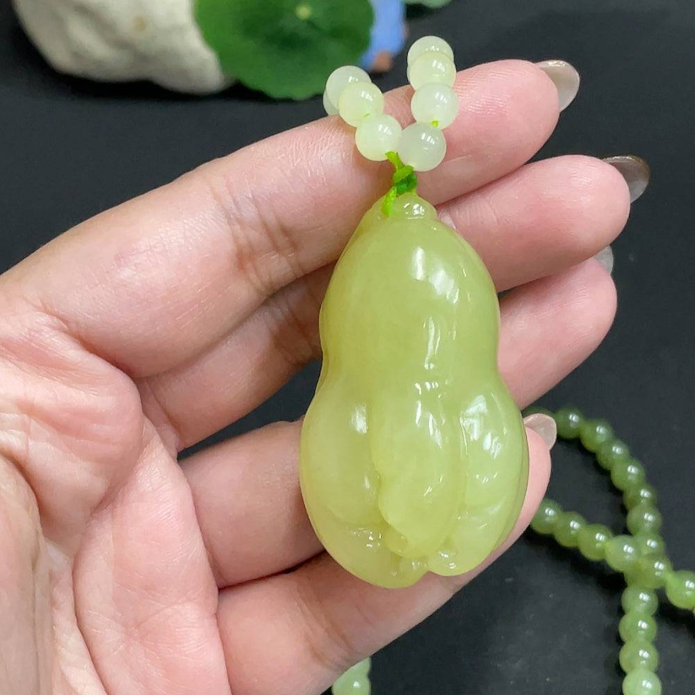 Huiliu Hetian jade pendant with bergamot color, displayed on a chain, showcasing smooth, polished jade with natural luster.