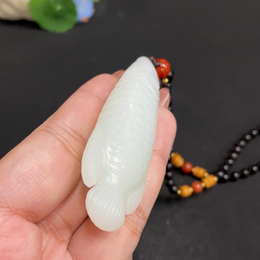 Huiliu certified Hetian jade pendant featuring intricate carvings, showcasing smooth, polished green jade stone design.