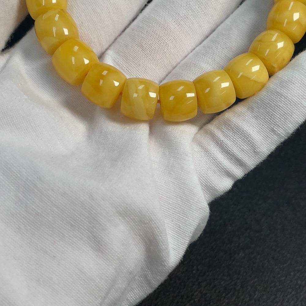 Huiliu amber beeswax bracelet with 11.2mm beads, natural amber color, certified by Huiliu, featuring a smooth, polished surface.
