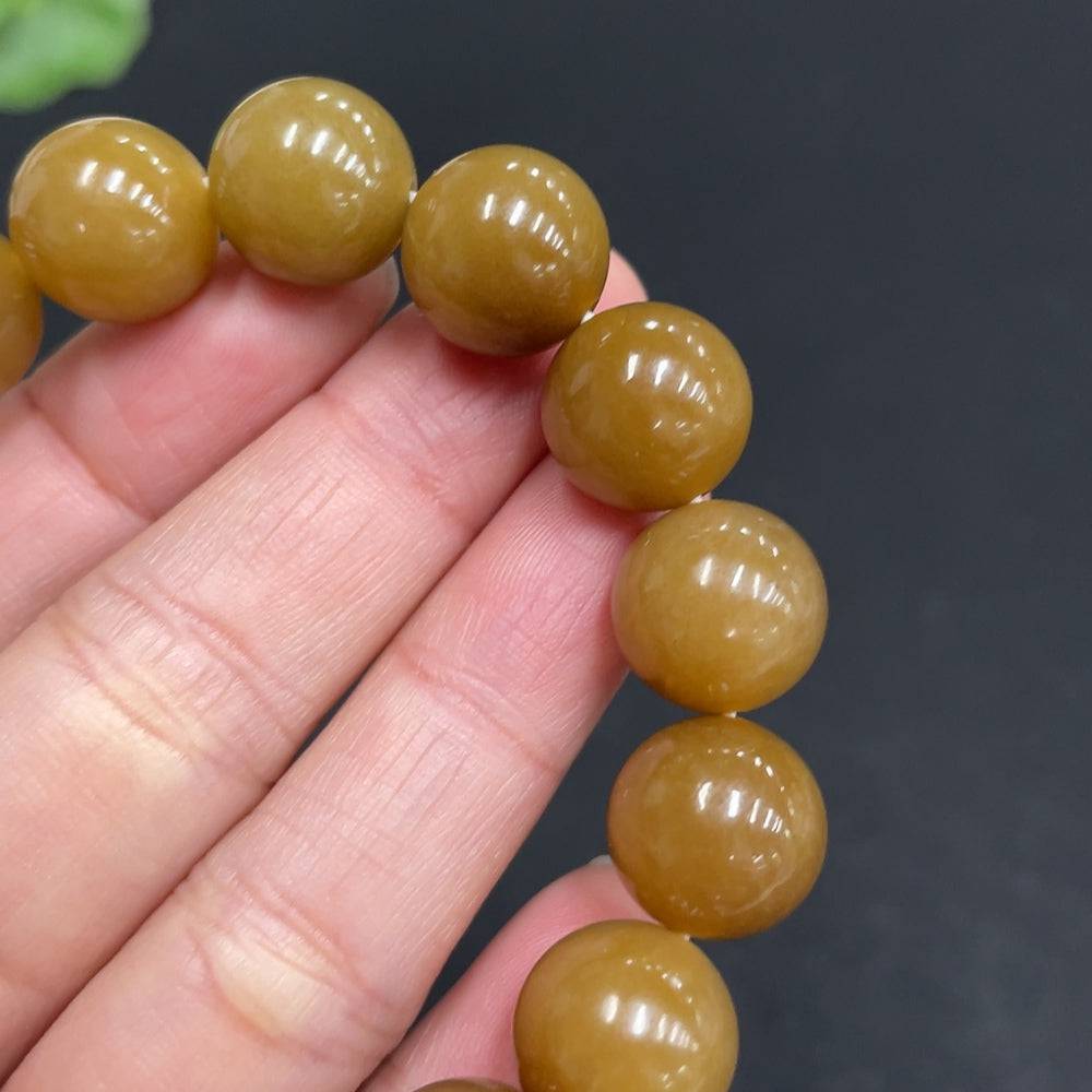 Hetian jade bracelet by HUILIU HQ with 11.6mm jade beads, weighing approximately 42g, showcasing smooth, polished jade stones.