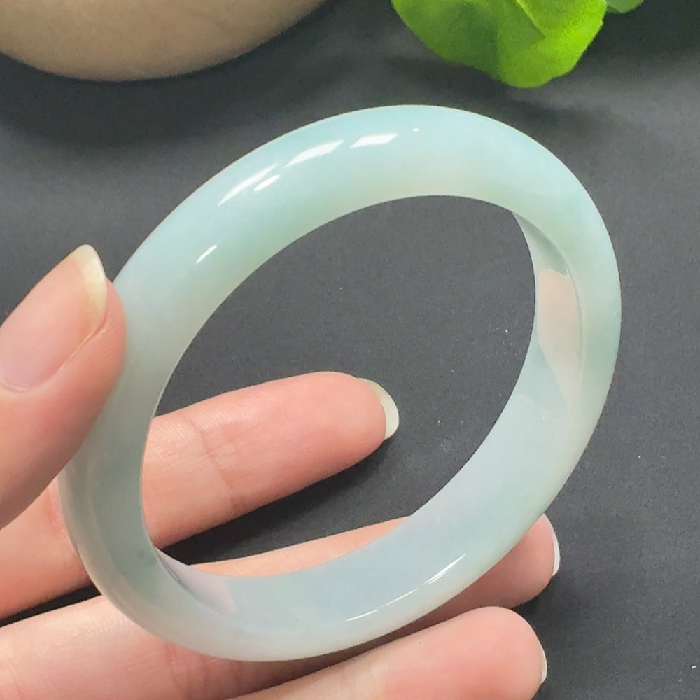 Jadeite round bangle with size 56.9 and weight 51.56g, crafted by HKHQ, showcasing smooth, polished green jade surface.
