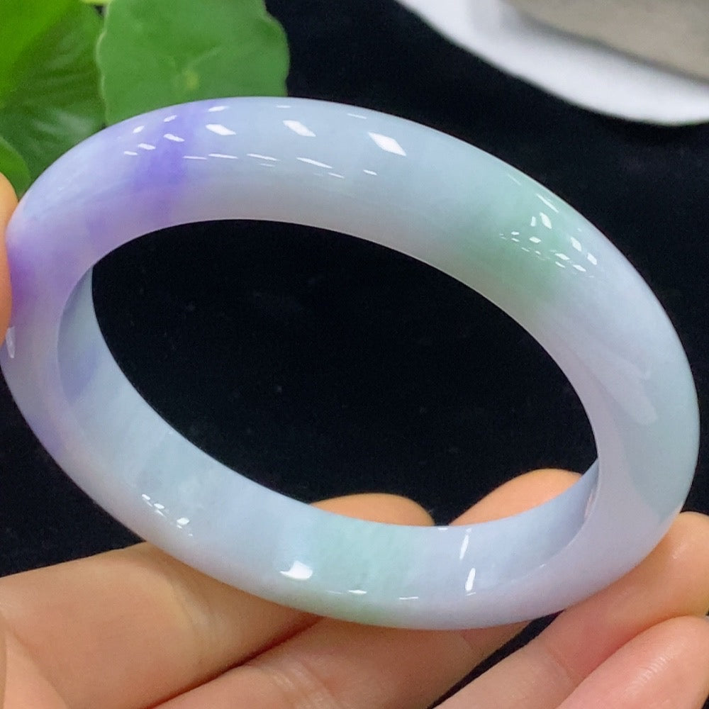 Jadeite bangle in size 59.3, weighing approximately 70.2g, featuring smooth green jadeite stones displayed on a white background.