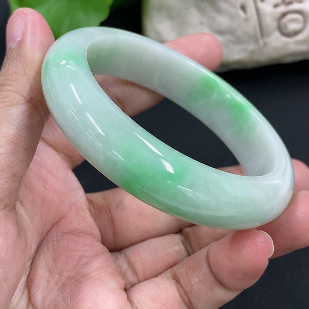 HKHQ jadeite round bangle in size 53.8 with a 56.6g weight, smooth polished jadeite bracelet shown on a display.