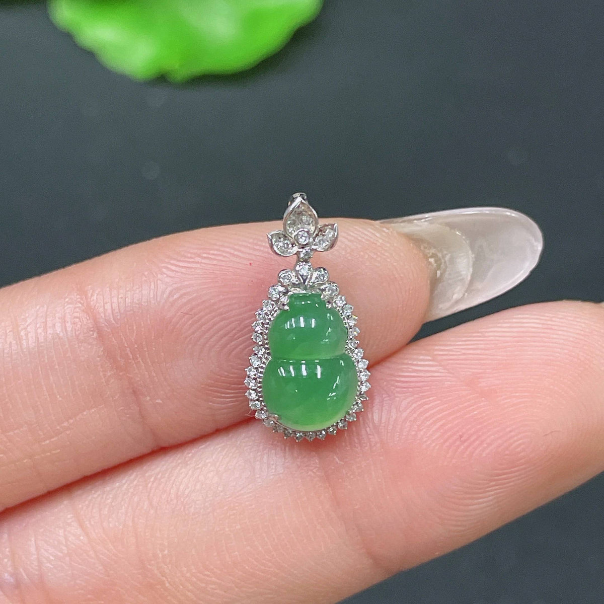 Jadeite gourd pendant with 18k gold and diamond inlay, featuring intricate design and polished jade surface, weight approximately 0.91g.