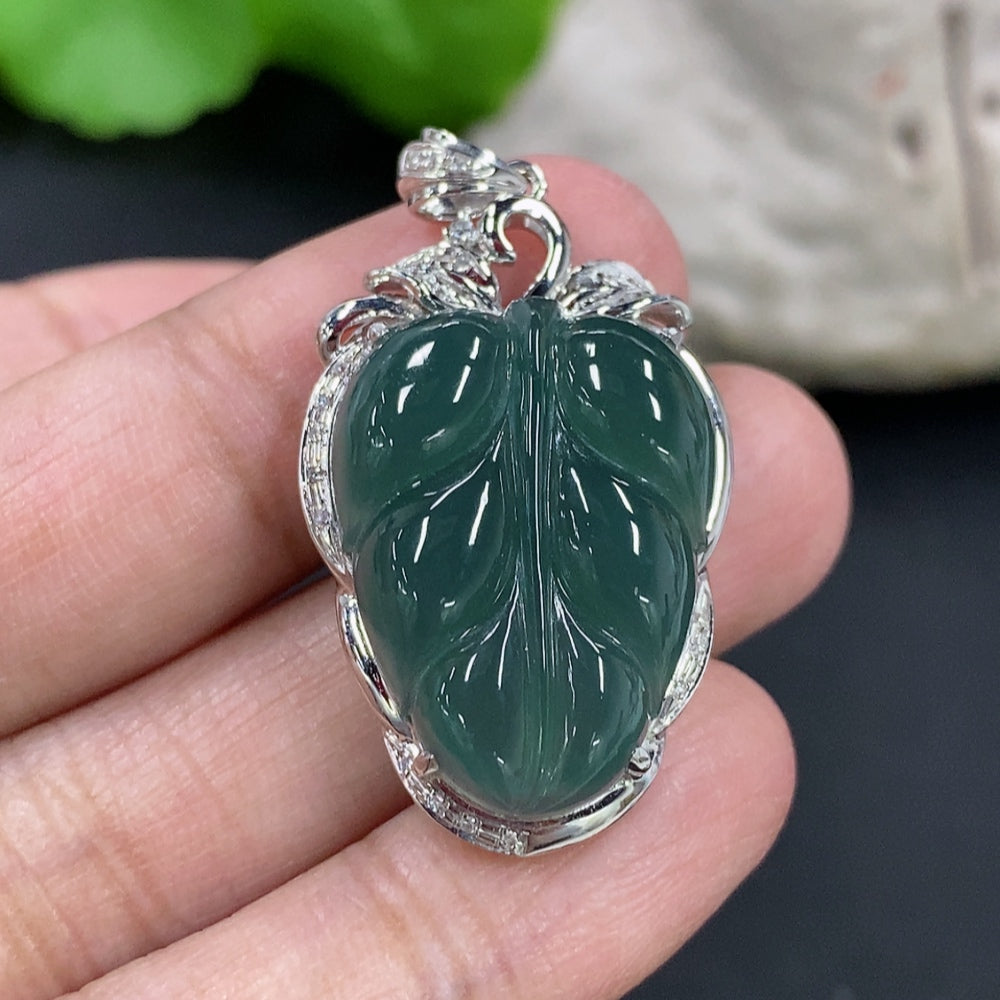 Jadeite leaf inlay pendant with 18K gold and diamond accents, displayed on a necklace chain. Elegant jewelry piece from HKHQ.