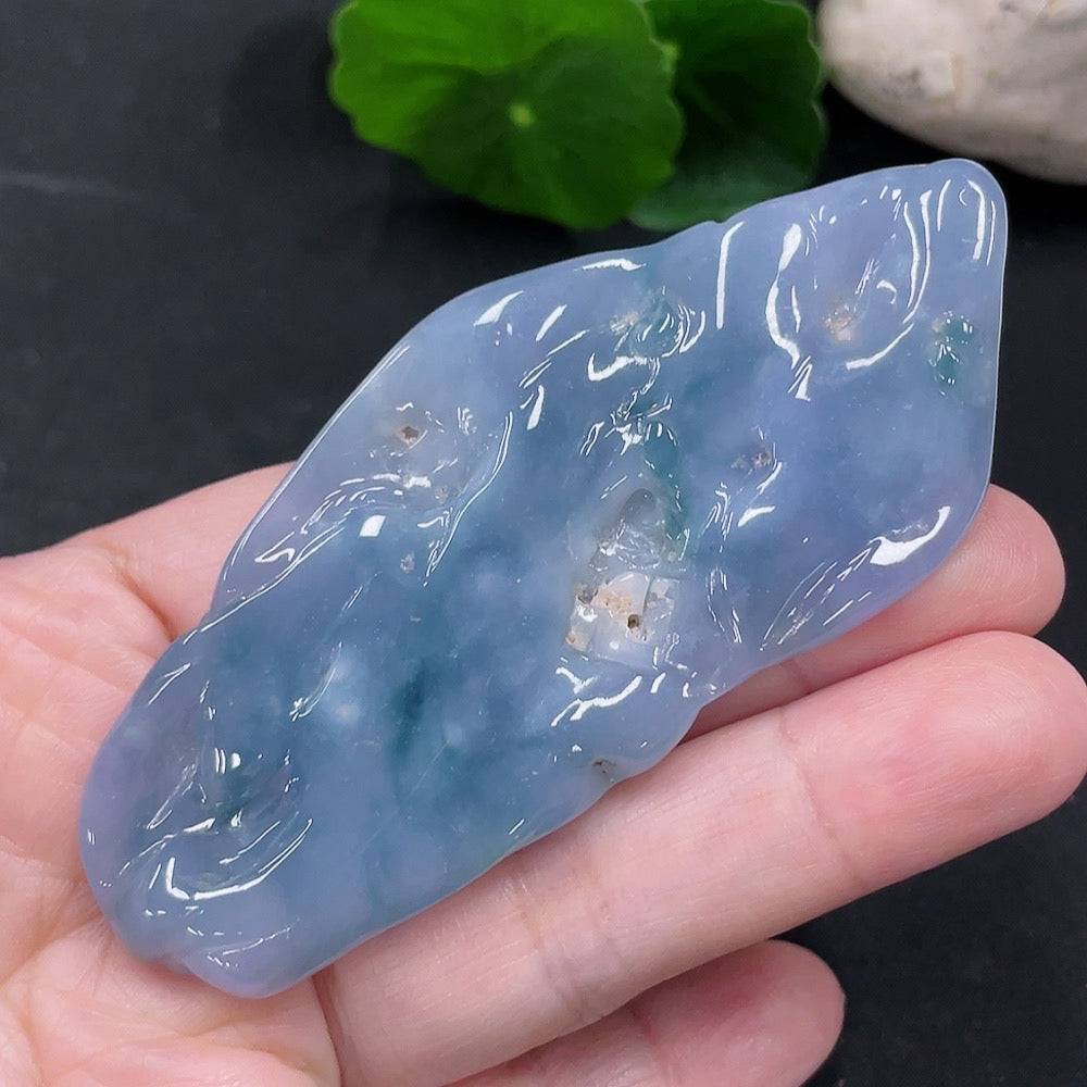 Huiliu Jadeite Enlightenment Pendant featuring polished, green jade with intricate carvings, hanging from a silk cord.