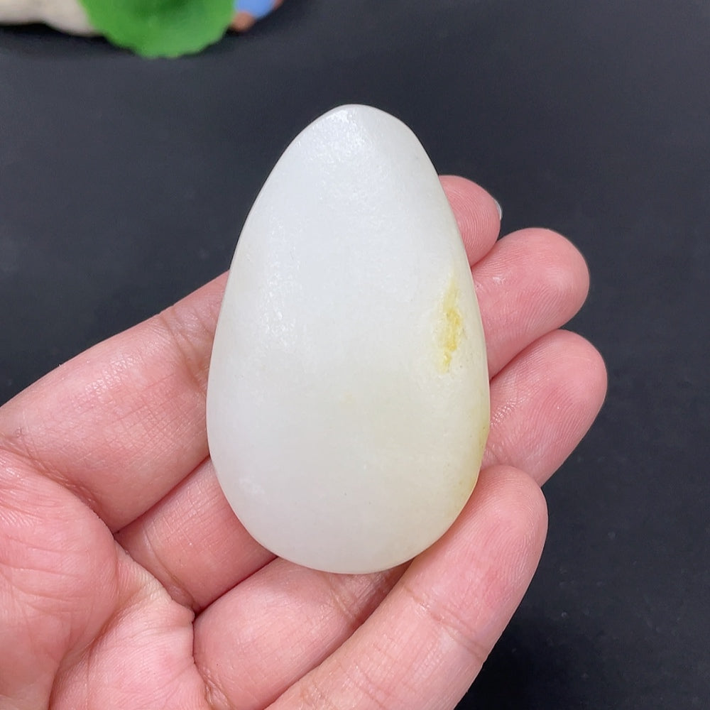 Huiliu certified Hetian jade Guanyin pendant with smooth, carved surface, showcasing natural jade color and intricate craftsmanship.