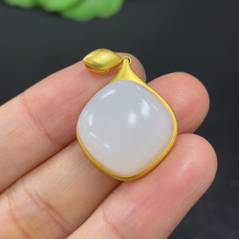 HKHQ Hetian jade inlaid pendant with 18K gold setting, featuring intricate design and polished surface, weighs 4.7g.