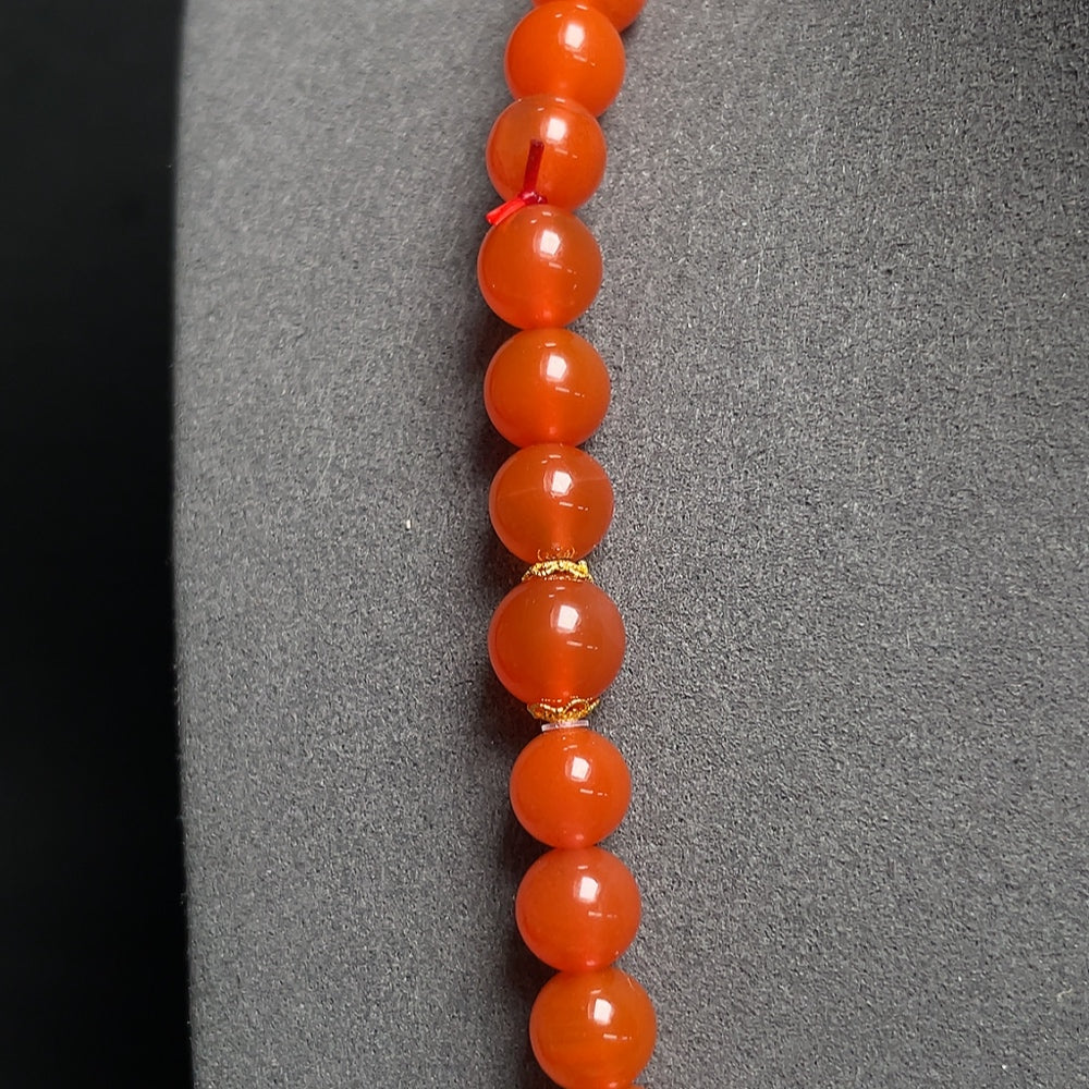 Red agate bead necklace with 18K gold, tourmaline, and pearl accents, showcasing elegant, colorful jewelry design.