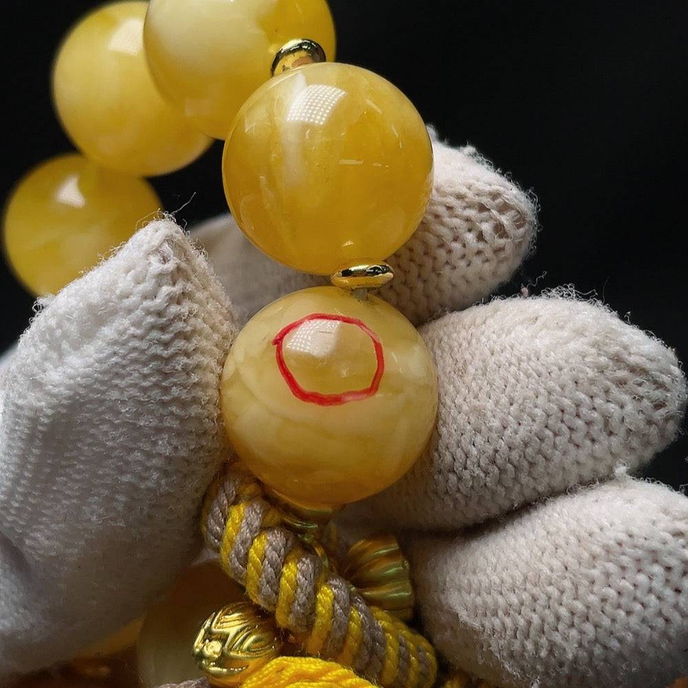 Amber beeswax bracelet by HUILIU HQ with visible repairs, cord, non-metal, accented with non-natural stones, size approximately 16.5mm.