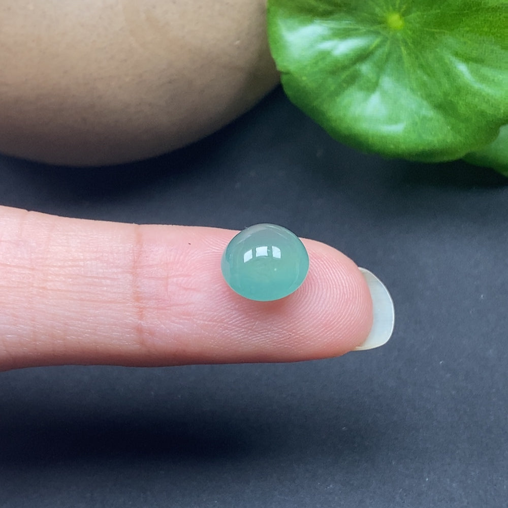 HKHQ jadeite cabochon inlay, approximately 0.75g, showcasing smooth, polished jade with vibrant green hues and unique natural patterns.