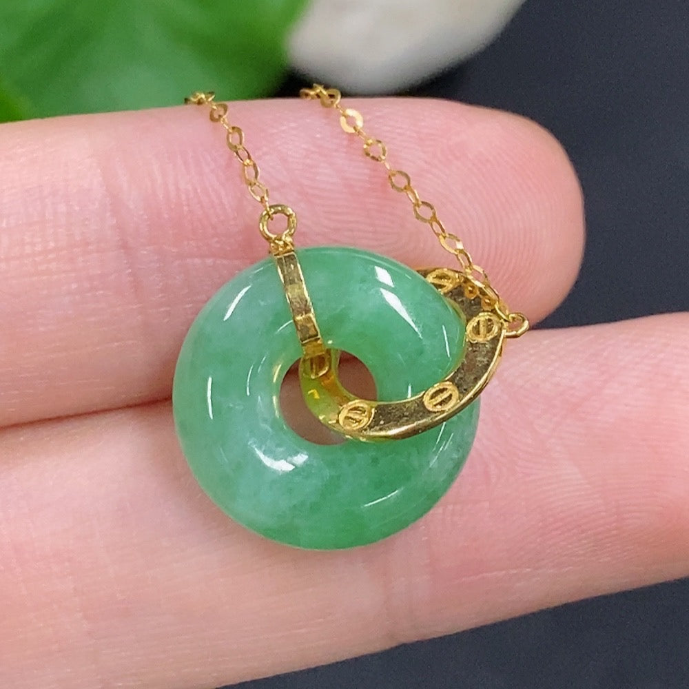 Jadeite donut pendant with 18k gold chain from HKHQ, showcasing a polished green jade circle necklace.