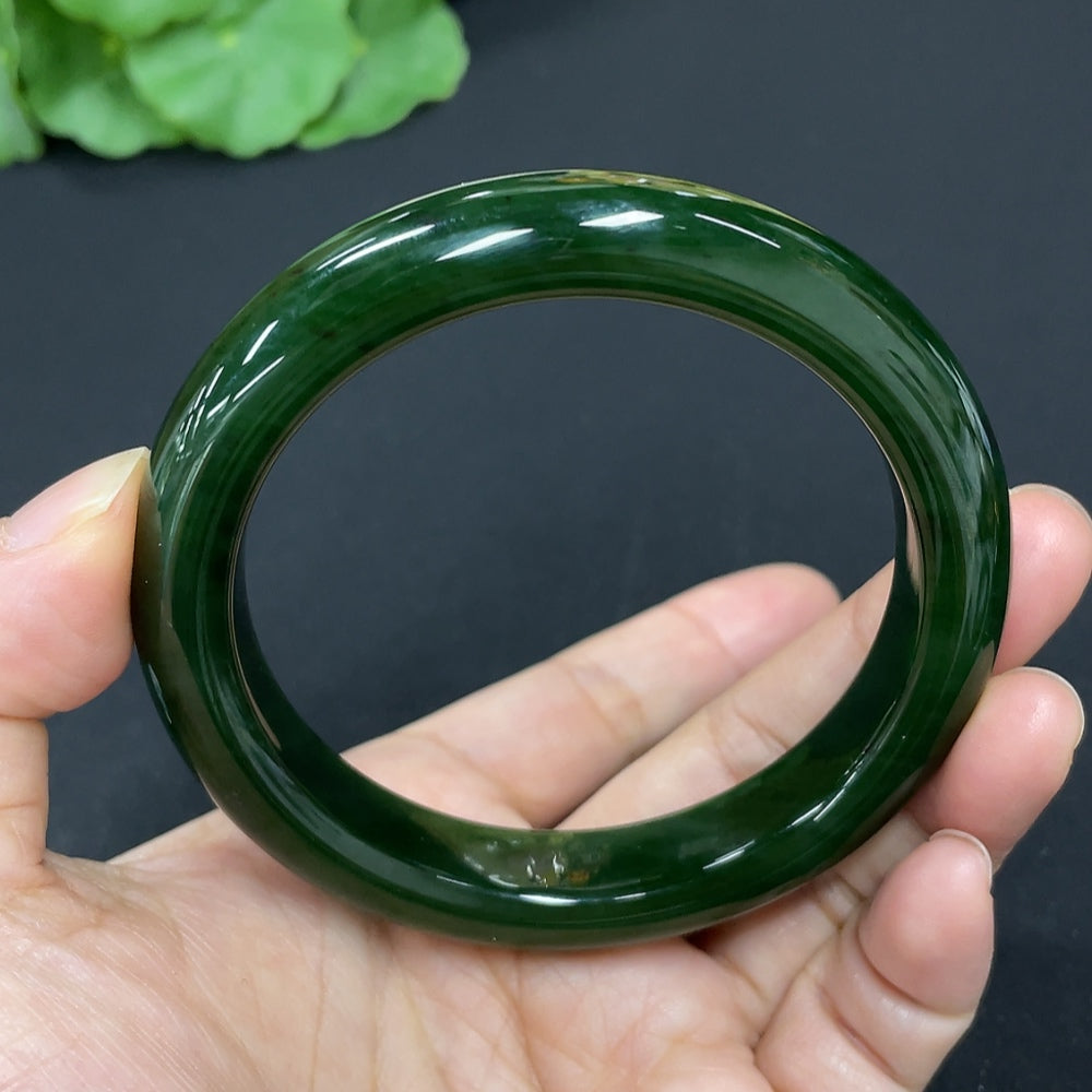 Green Hetian Jade round bangle bracelet featuring smooth, polished surface and traditional craftsmanship by HKHQ.