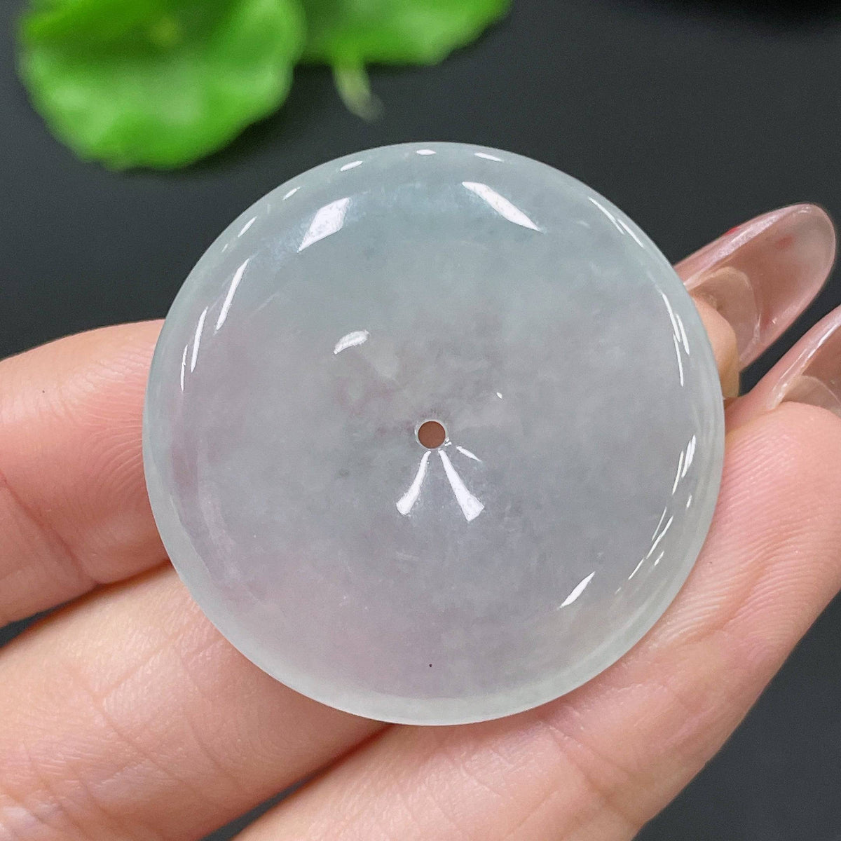 Jadeite pendant with peace knot design, weighing about 11.4g, crafted from green jade by HUILIU HQ, shown hanging on a cord.