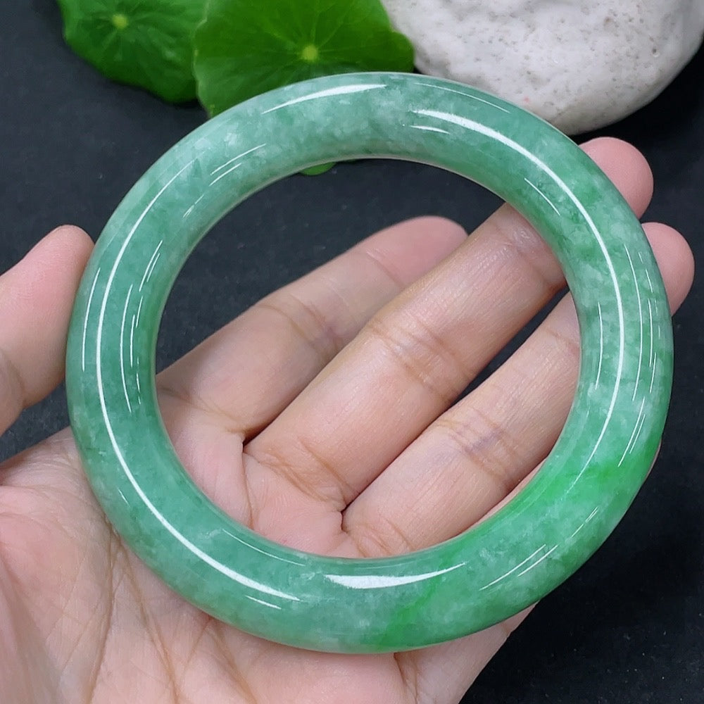 Jadeite round bangle in size 55.5mm, weighing approximately 76.95g, featuring smooth, polished jade surface, HKHQ brand.