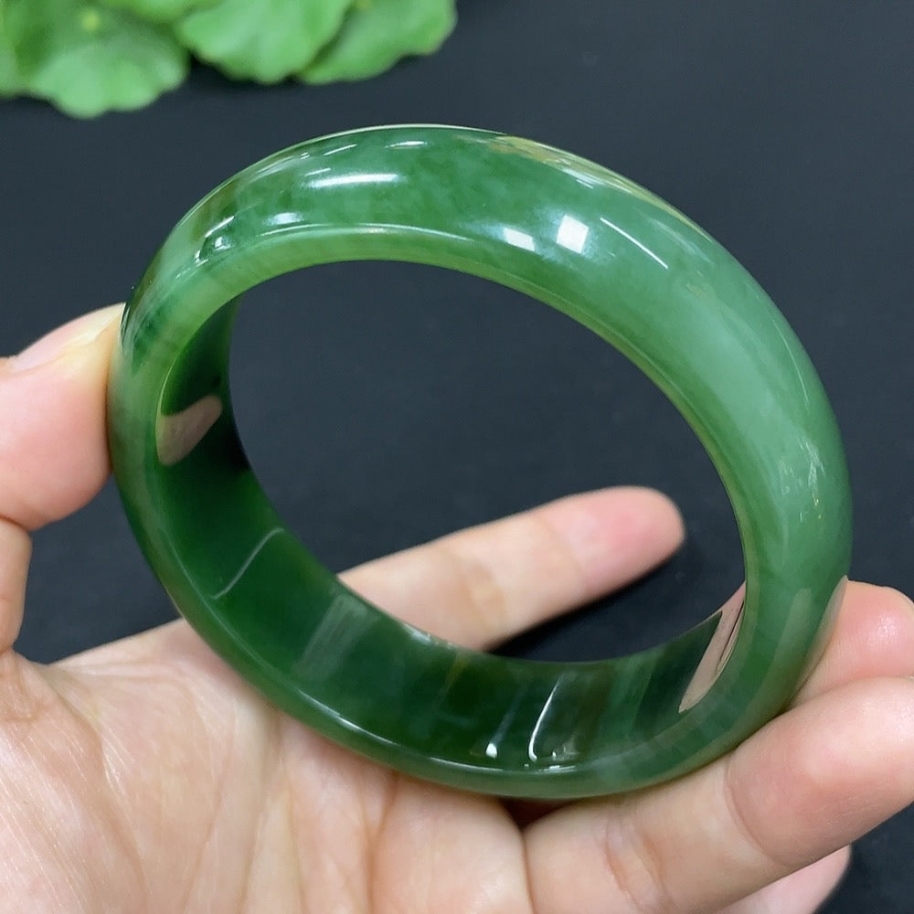 Green Hetian Jade round bangle bracelet by HKHQ, smooth polished surface, traditional jewelry design, showcasing elegant craftsmanship.