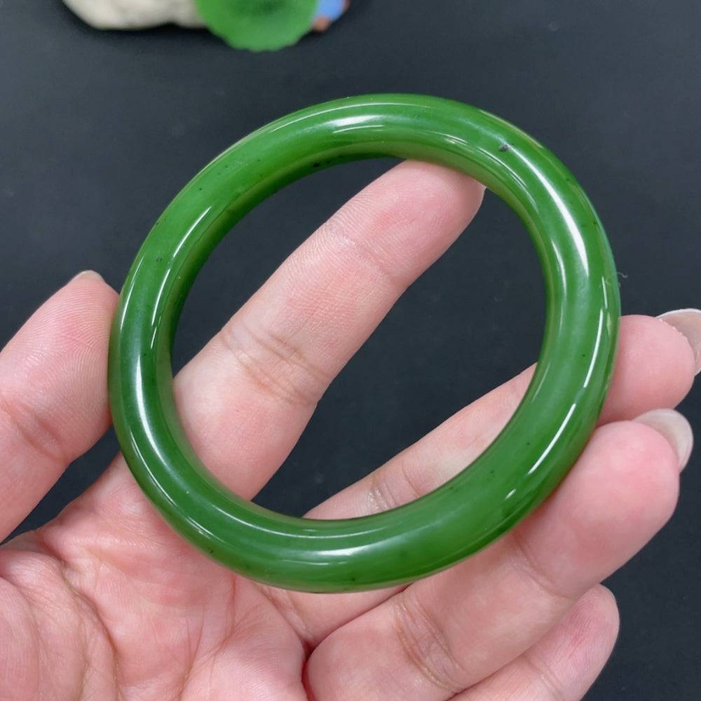 Huiliu certified Hetian jade round bangle showcasing smooth, polished jade with natural green and white marbling.