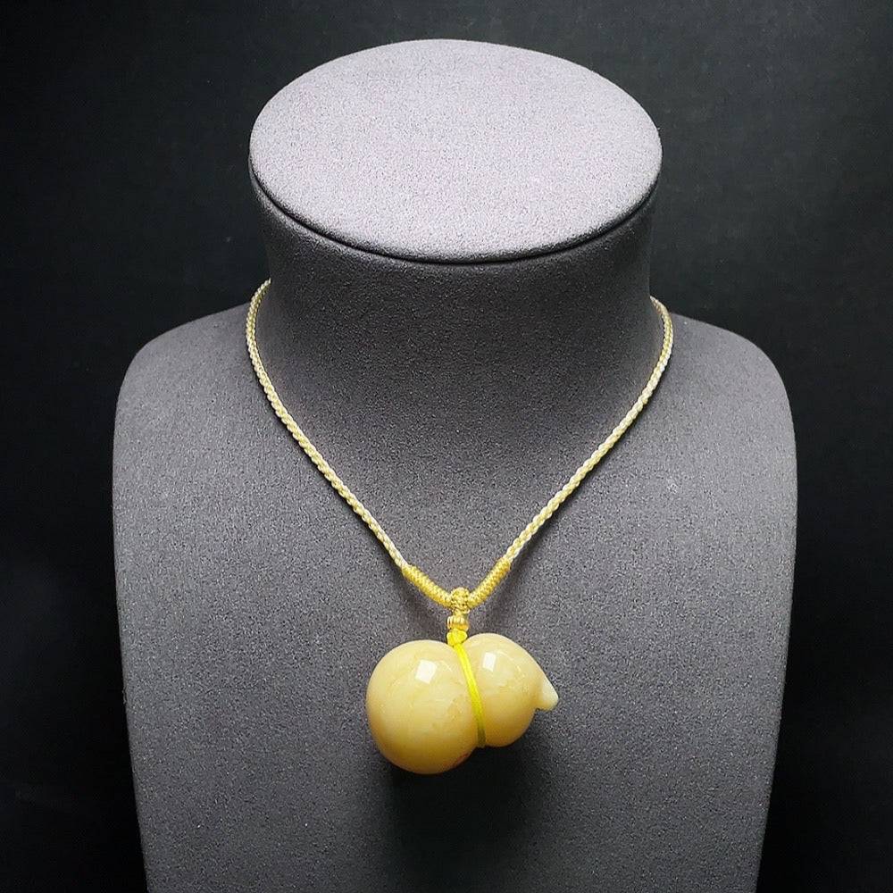 Huiliu Amber beeswax pendant with partial visible repairs, showcasing warm amber color and handcrafted details.