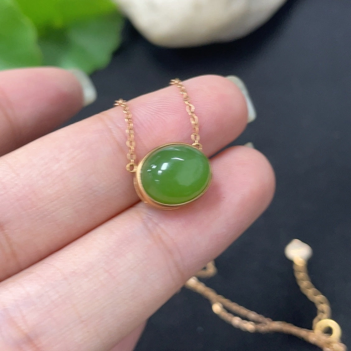 Hetian jade inlaid pendant with 18k gold setting, HKHQ necklace featuring a delicate chain and a polished jade centerpiece.