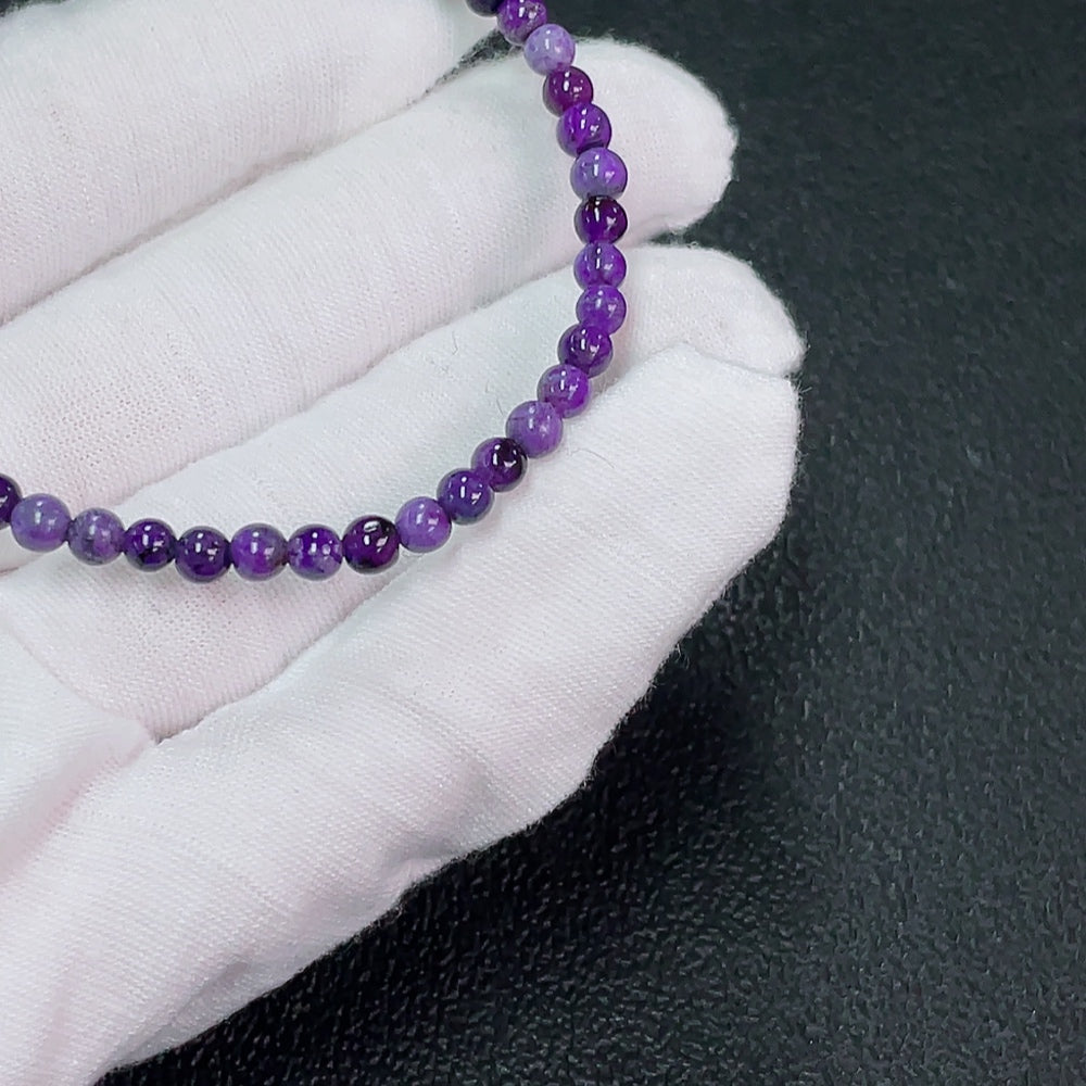 Purple Sugilite gemstone bracelet with 4mm beads and mineral components, weighing approximately 4.32g, featuring organic matter.