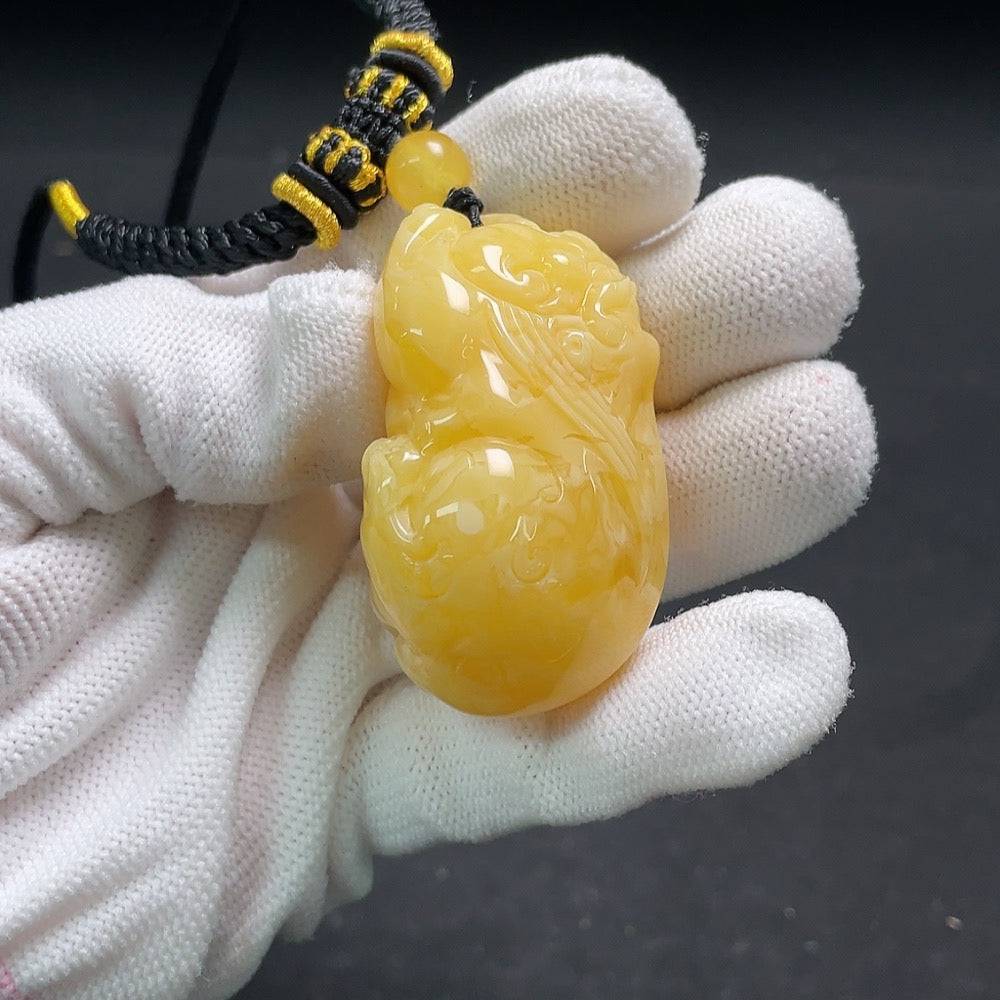 HUILIU HQ amber beeswax pendant with rope, showcasing a smooth amber piece in a natural, polished finish.