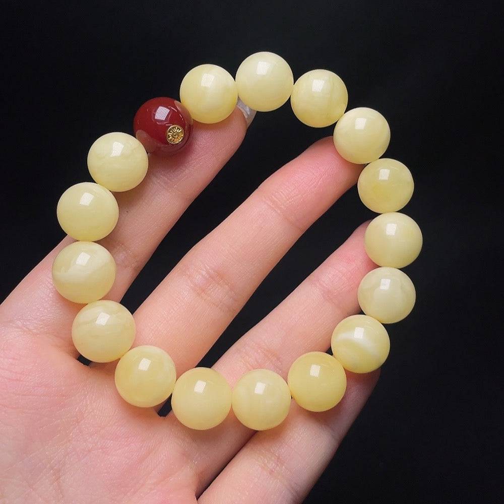 HUILIU HQ amber beeswax bracelet with 12.3mm beads featuring non-natural stones, displayed close-up with natural lighting.