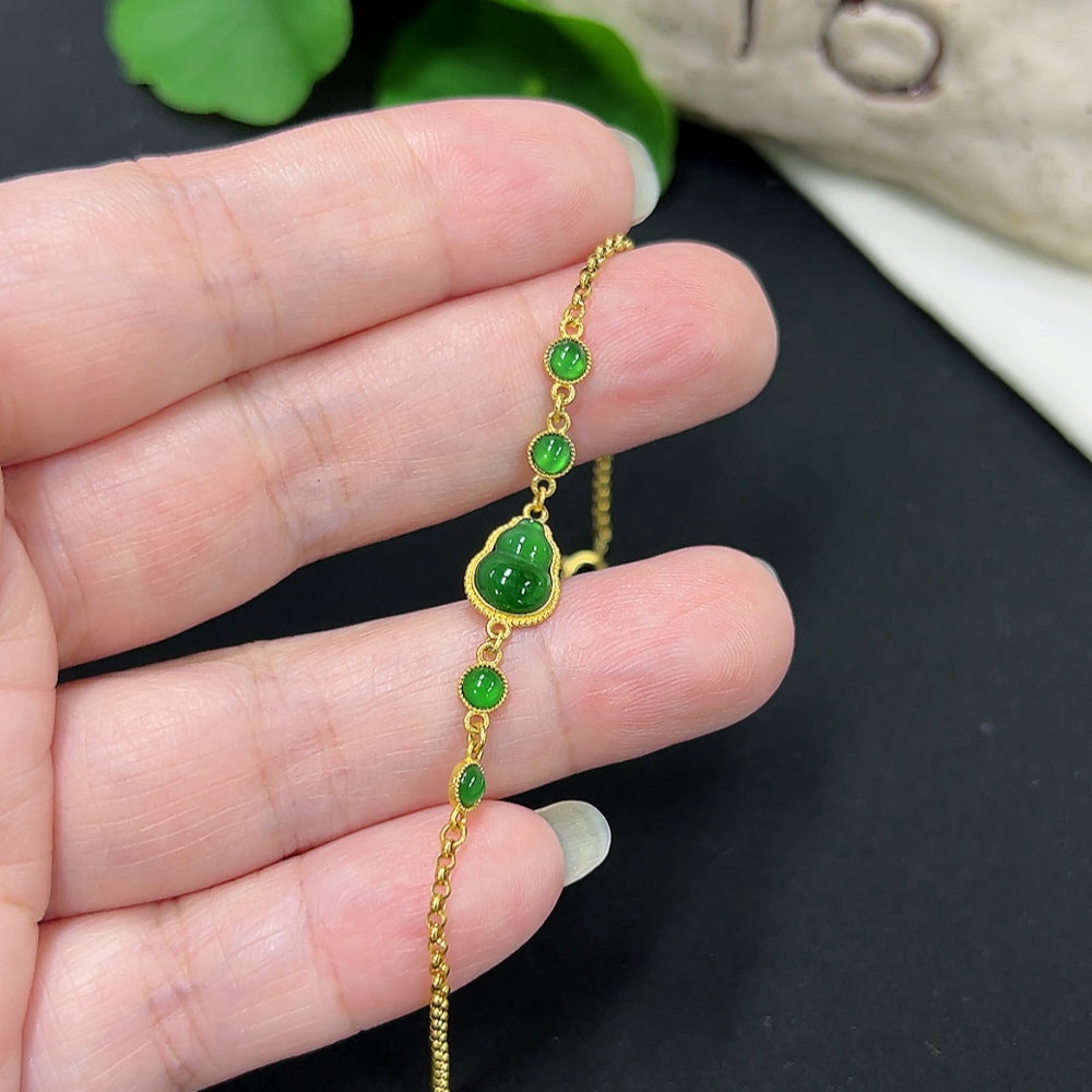 HKHQ jadeite inlaid bracelet with 18K gold, delicate design, showcasing green jade stones and gold accents.