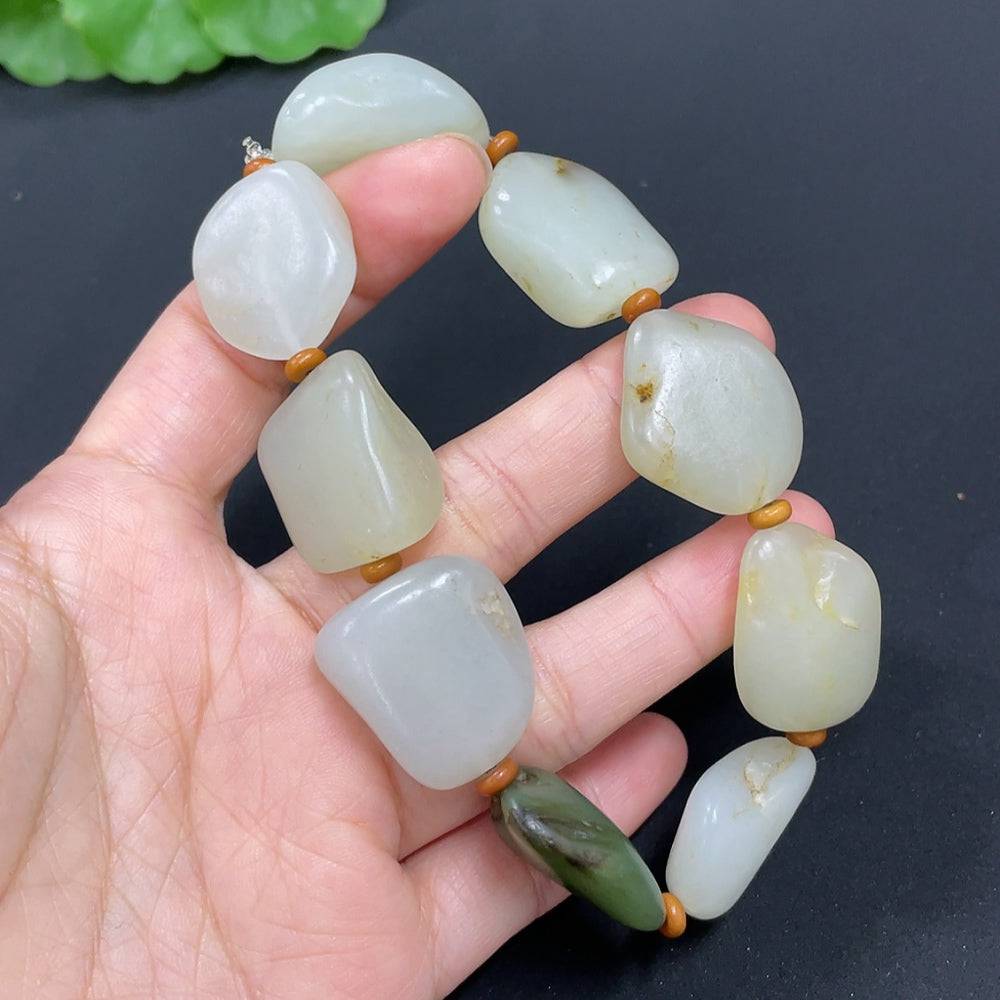 Huiliu HUILIU HQ Hetian Jade bracelet with smooth, polished green jade beads on an undetermined skin tone model.