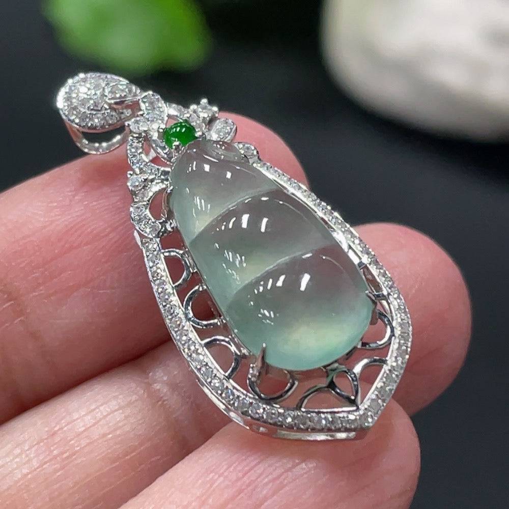 Jadeite blessing bean pendant with 18K gold setting and diamond accents, featuring a smooth, polished jade gemstone.
