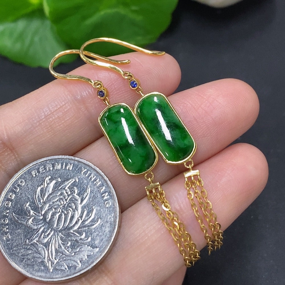Jadeite earrings with 18K gold setting, showcasing smooth green jade stones and elegant gold hooks in a close-up view.