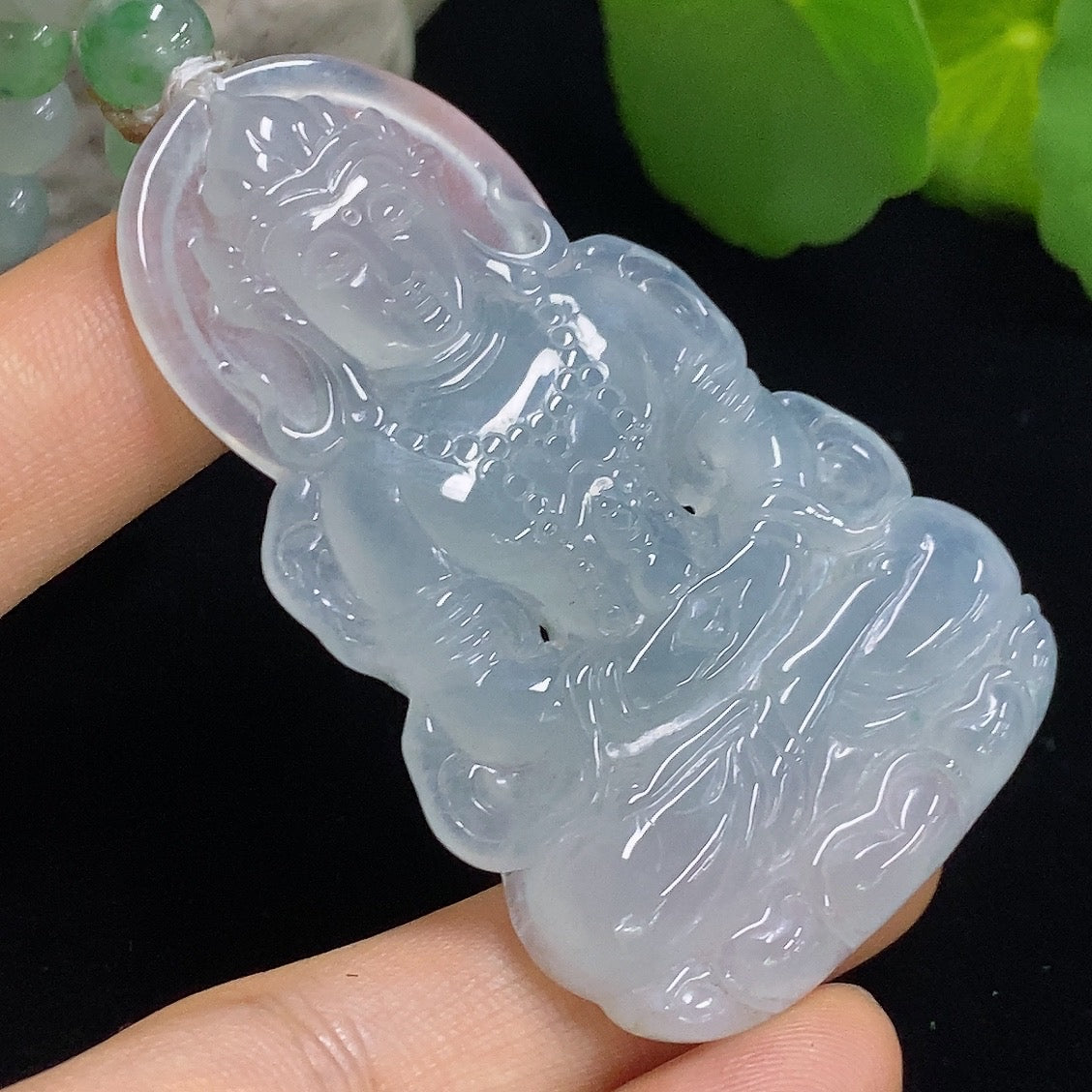 Jadeite Tara pendant from HKHQ featuring a detailed carved jade figure on a cord necklace.