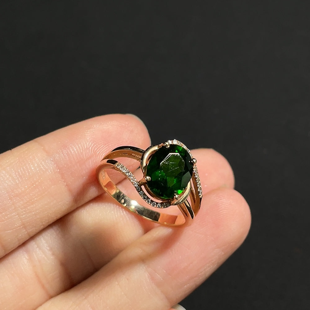 Diopside ring with diamond accents set in 18K gold, elegant jewelry piece featuring a central green gemstone and sparkling side diamonds