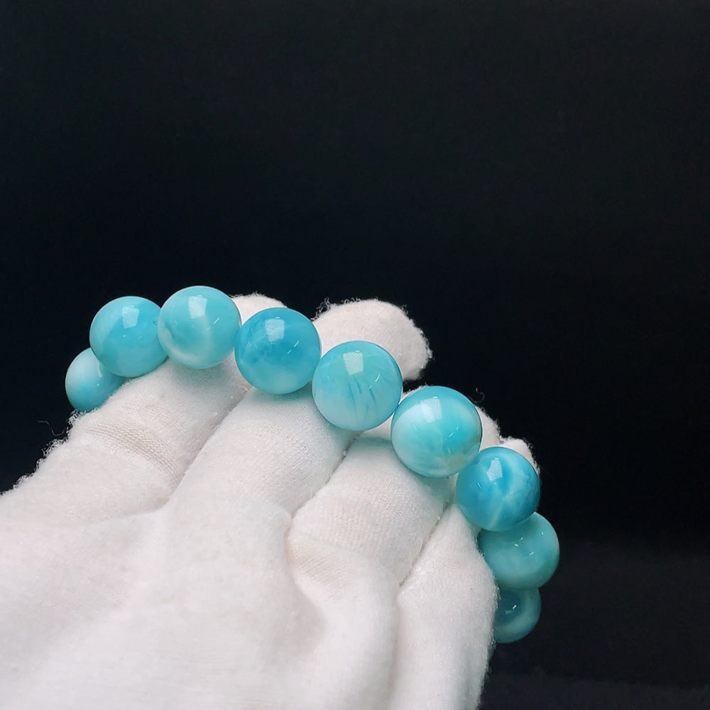 Larimar gemstone bracelet with organic matter, weighs 56.14g, 13.8mm size, featuring vibrant blue stones and unique natural inclusions.