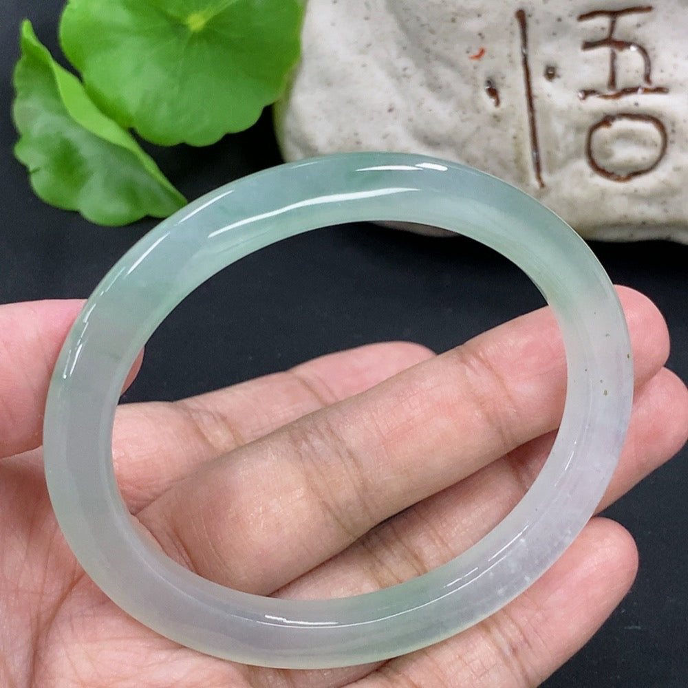 HKHQ jadeite oval bangle, size 55.3, 24.3g, showcasing smooth green jadeite with polished finish on a plain background