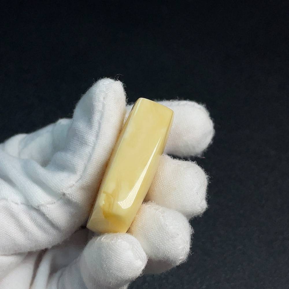 Amber beeswax pendant from HUILIU HQ with natural amber color, showcasing a smooth, polished surface and unique organic shape.