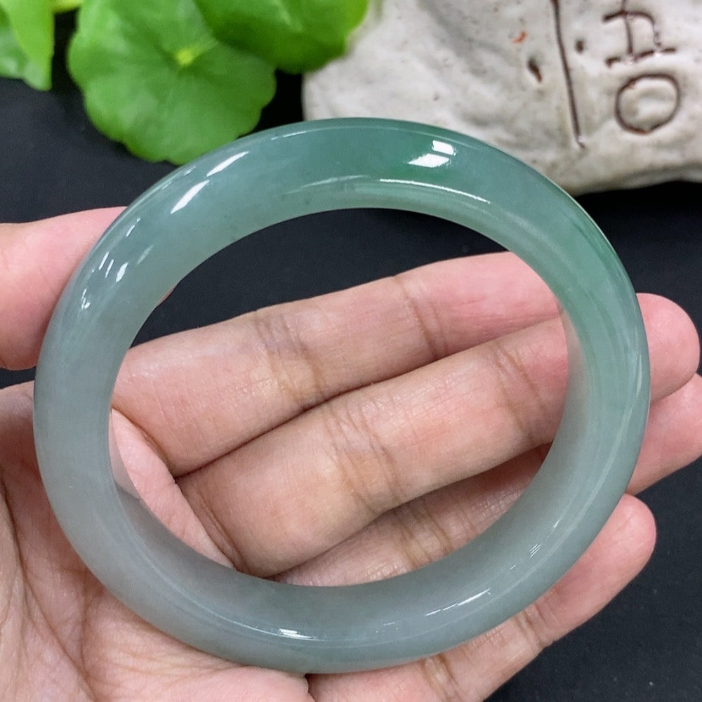 HKHQ jadeite round bangle with size 55.5 and 53.26g, showcasing smooth, polished jadeite bracelet on a neutral background.