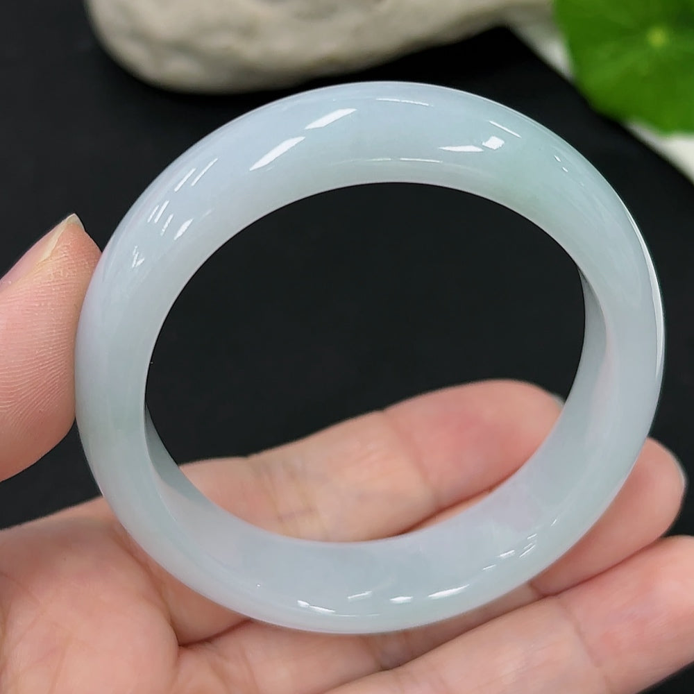 HKHQ jadeite oval bangle in size 54.6, weighing 44.9g, featuring a smooth, polished green jade surface.