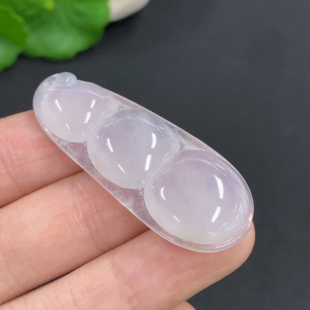 Jadeite lucky bean pendant from HUILIU HQ showing smooth, green jade with carved detailing and a metal loop for hanging.