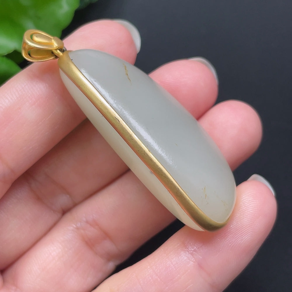 Hetian Jade inlaid pendant on 18K gold necklace, featuring HKHQ branding, with intricate design and a polished finish.
