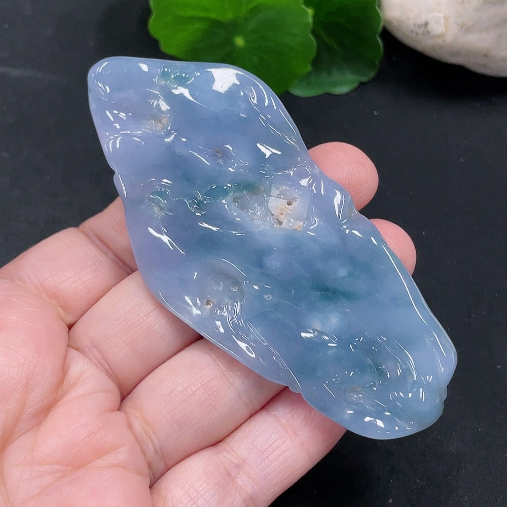 Huiliu Jadeite Enlightenment Pendant showing smooth, green jade pendant with intricate carvings on a silk cord.
