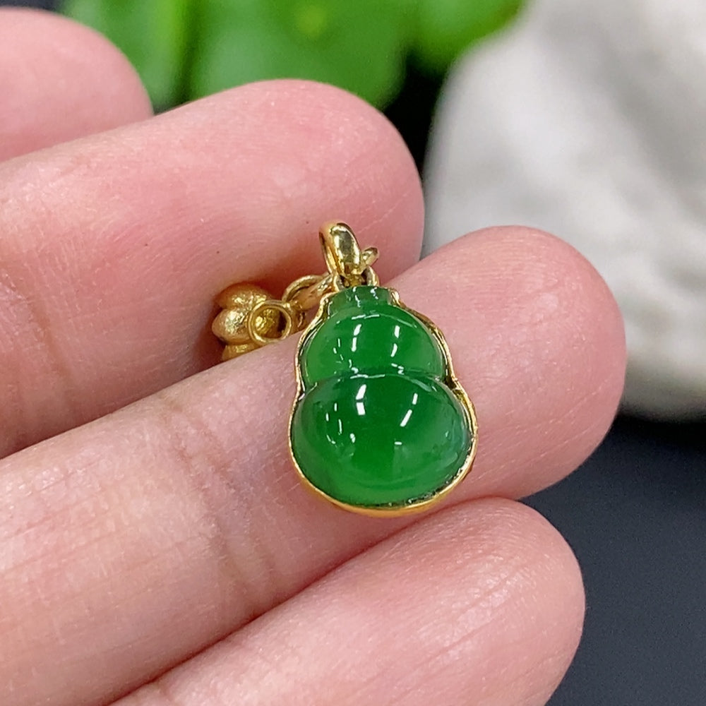 Jadeite gourd pendant with 18K gold setting, hanging from a delicate necklace, showcasing intricate craftsmanship and vibrant green jade.