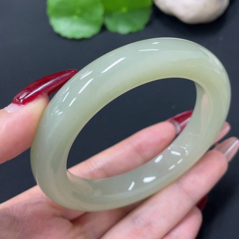 Huiliu Hetian jade round bracelet with smooth polished beads, showcasing natural green and white hues on a white background.