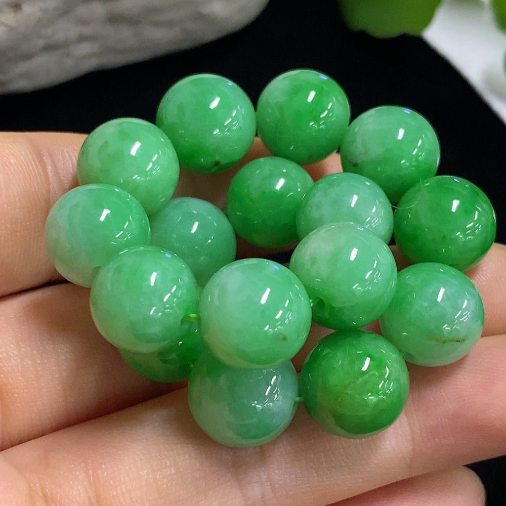 HKHQ jadeite bracelet with 11mm beads, showcasing smooth green jade stones and a total weight of approximately 43 grams.