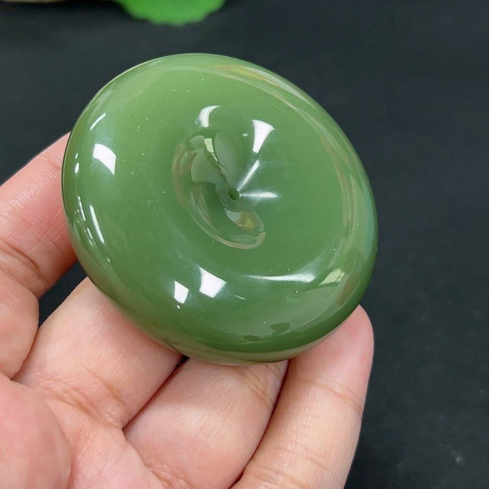 Huiliu certified Hetian jade pendant in peace button design, featuring smooth, polished green jade with intricate carvings.